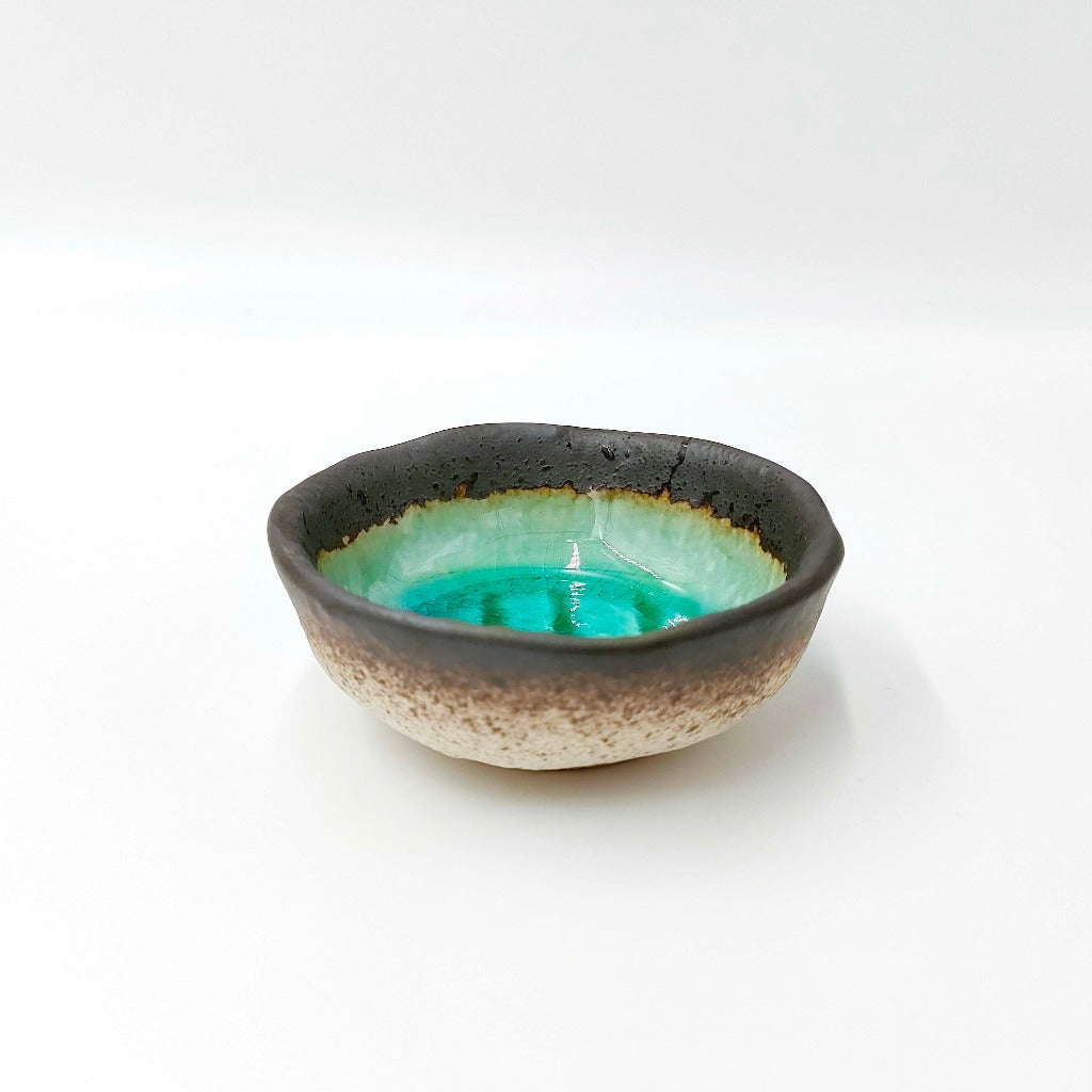 side view of Maruchiyoku Mamezara with green crackle glaze design on interior surface 