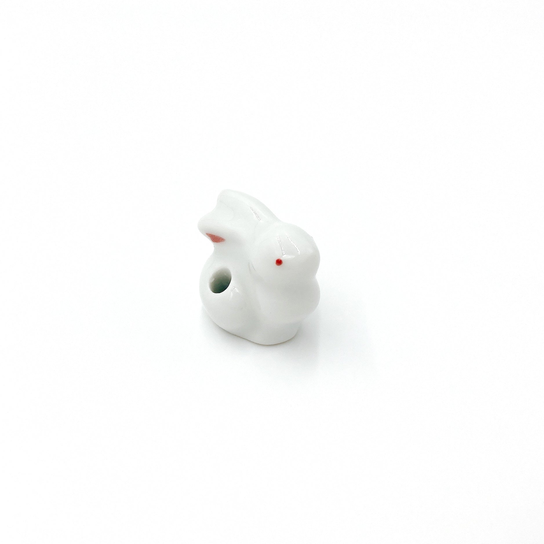 close up angled view of pink and white ceramic Kyūkyodō Incense Set bunny incense stick holder right side