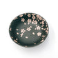 Sakura themed side bowl. Top down view of black bowl with pink sakura petals decorating the inside of the bowl.
